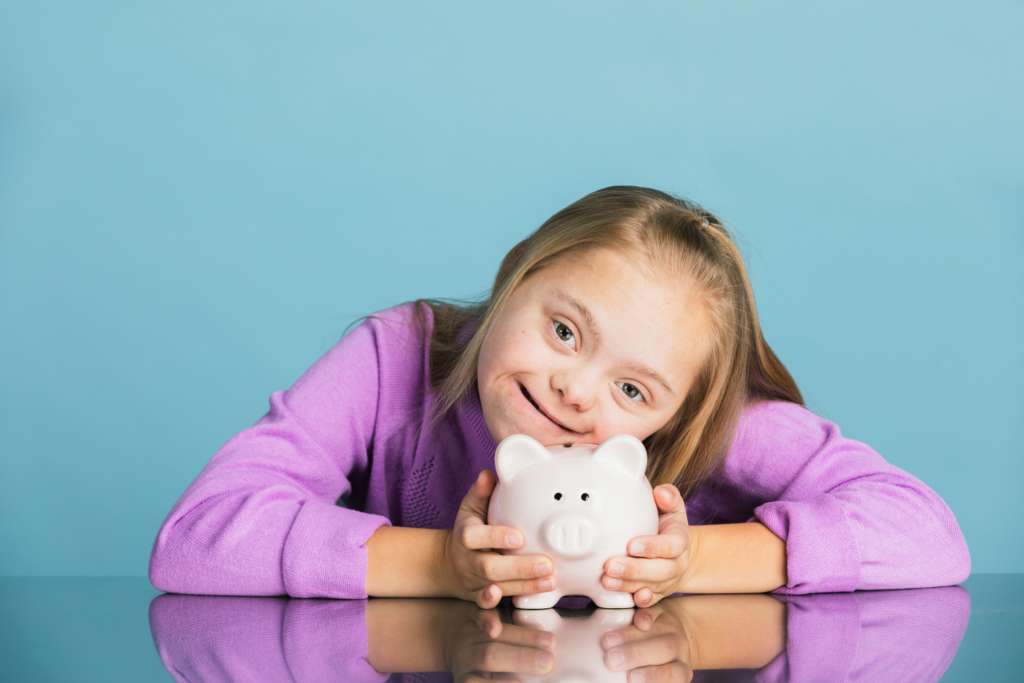 Young girl with down syndrome holding a piggy bank