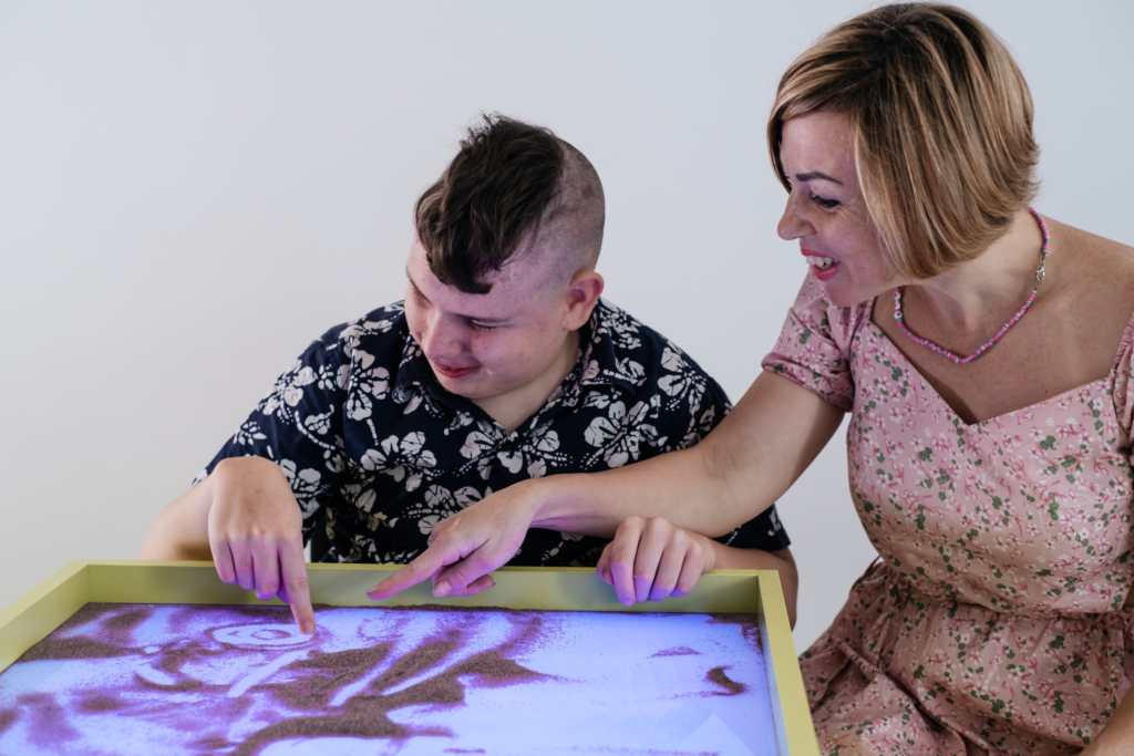 Disabled child doing a sensory activity with sand
