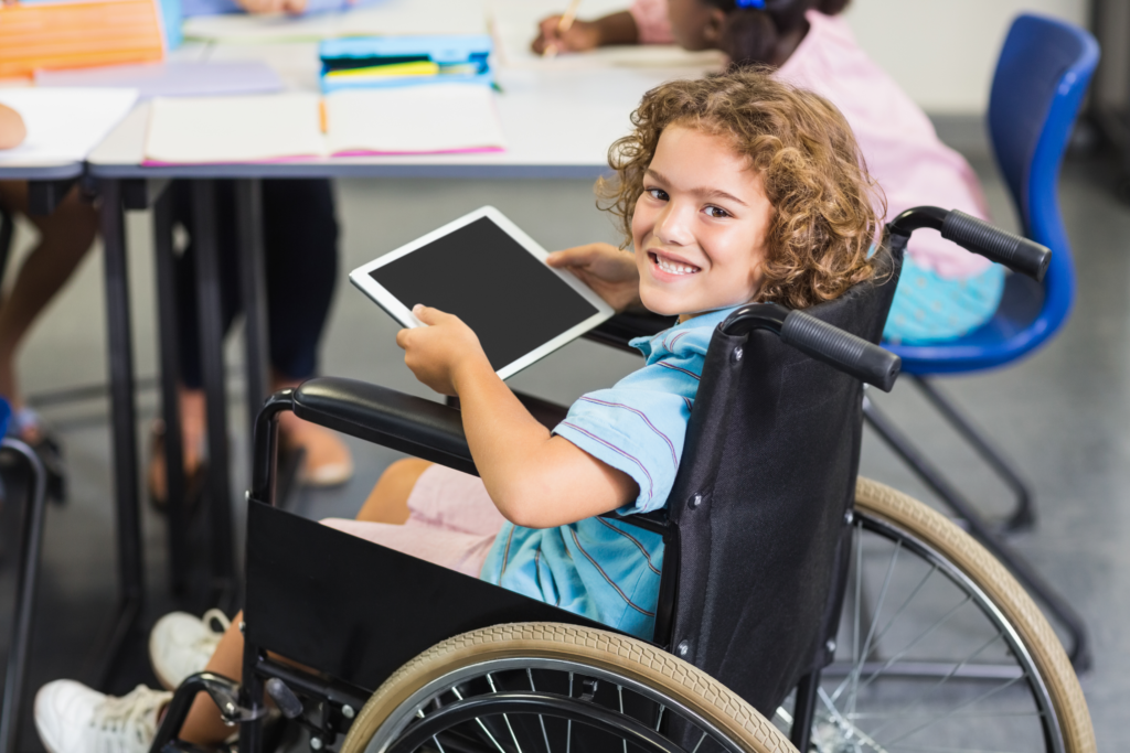 Image of a young boy in a wheelchair with a tablet device