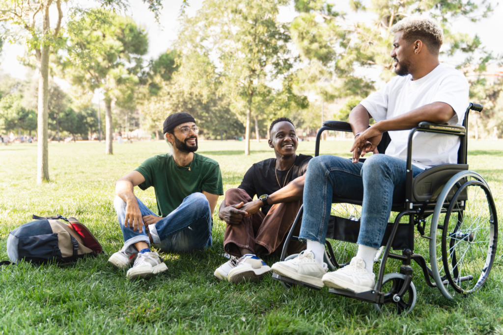 Image of students talking while sitting on a field.